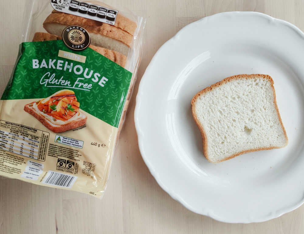 A loaf of Bakers Life Bakehouse Gluten Free White Bread next to a slice.