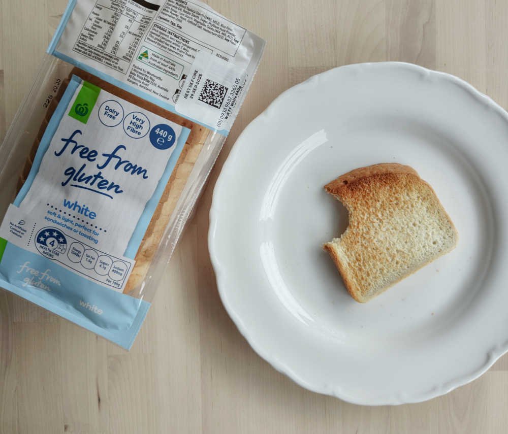 Woolworths Free From Gluten White Loaf next to  a toasted slice on a plate.