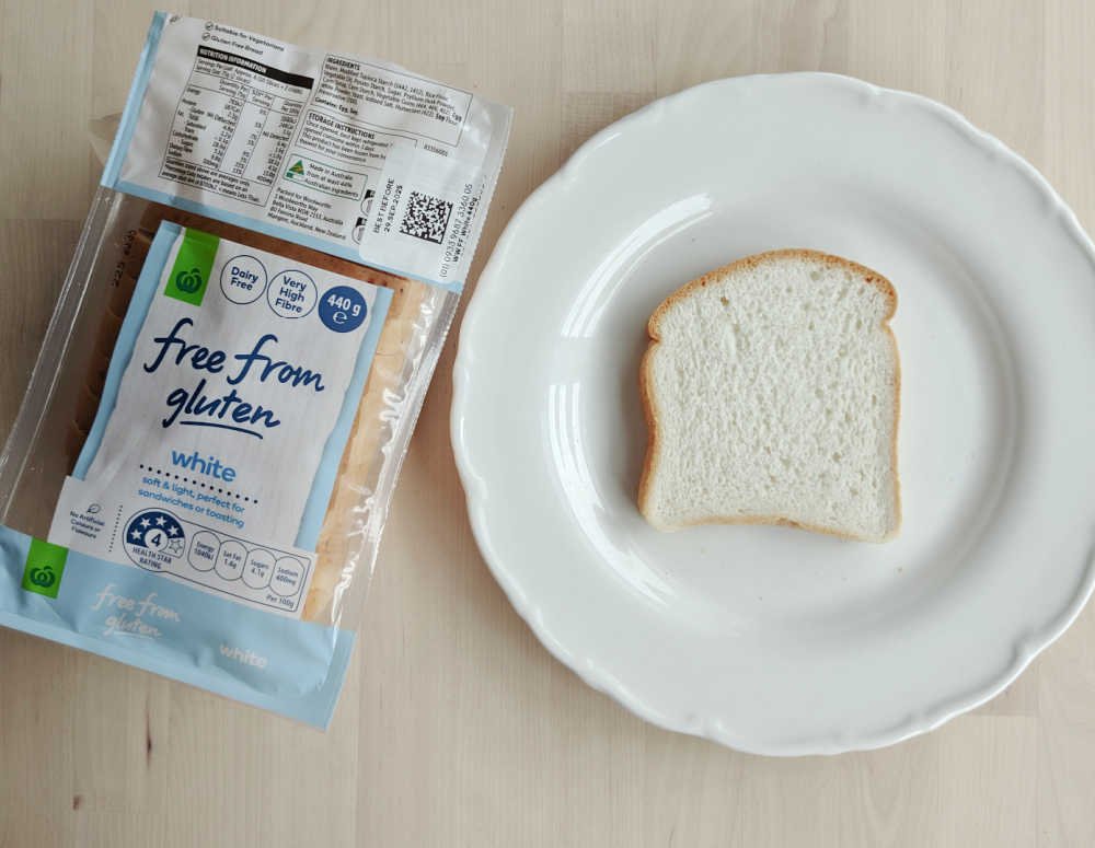 Woolworths Free From Gluten White Loaf next to a slice on a plate.